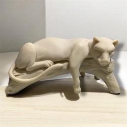 scultura in ceramica raffigurante una pantera sdraiata su un tronco